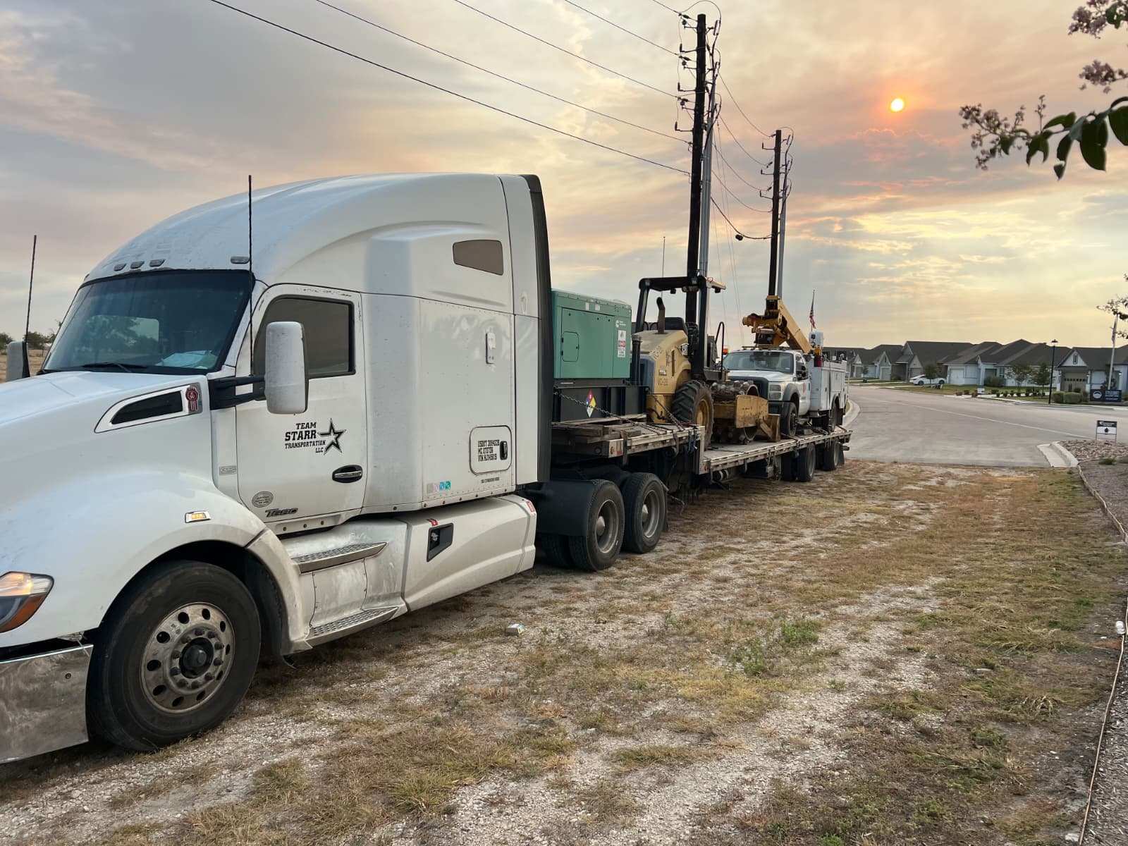 Team Starr tractor at sunset hauling equipment